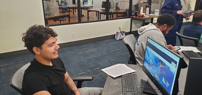 A man looks at a computer monitor showing the U.S. Coast Guard website. A man looks at a computer monitor showing the U.S. Coast Guard website.